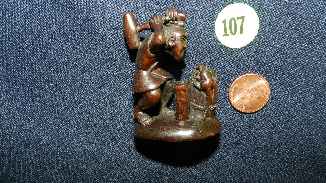 Unusual carved ironwood Netsuke of man with mattet: Unusual carved ironwood Netsuke of man with mattet over rat- signed