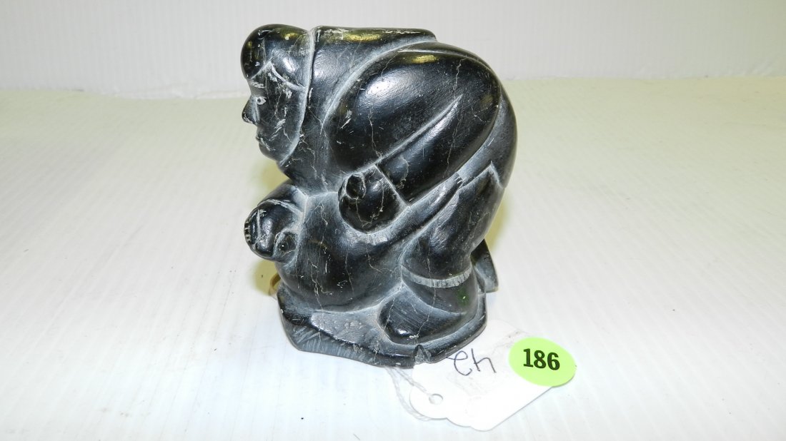 Inuit Shaman soapstone carving, smoothly carved black: Inuit Shaman soapstone carving, smoothly carved black steatite figure of man resting on a seal w/ delicately incised features & stoic expression, signed SHAMAN 3/17 & EY on base. 3 1/4" L x 3 1/4"H
