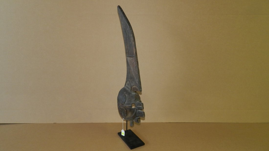 1301) Wonderful African carved Igbo stylized mask w/: 1301) Wonderful African carved Igbo stylized mask w/ long crest, raised facial design, attached to display, COND G, shows loss from age, mask is 31" Tall, w/stand 35 1/2