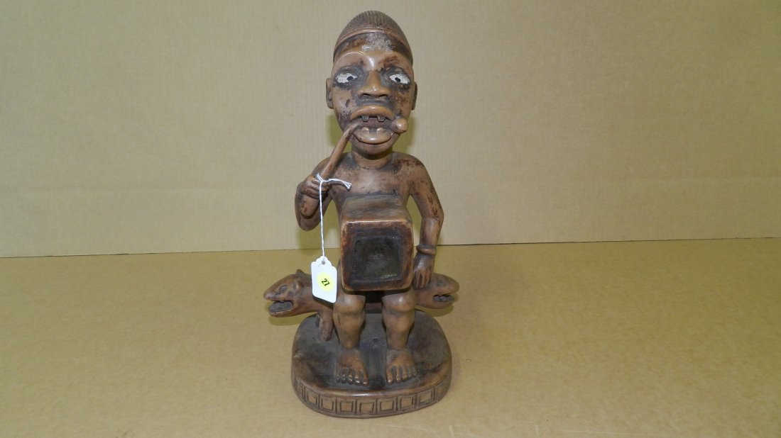 698) Wonderful hand carved African Seated fetish figure: 698) Wonderful hand carved African Seated fetish figure w/ mirror, sitting on double headed dog / mythological creature. Judgment vine mouth. Glass eyes. COND G, 14 1/4 Tall