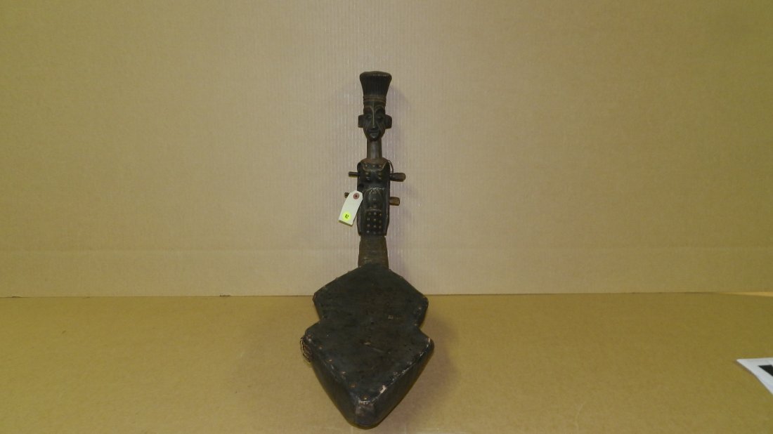 3250) Unique hand carved African Mangbetu harp, with: 3250) Unique hand carved African Mangbetu harp, with carved figure top, metal decoration, 28 x 8 1/2
