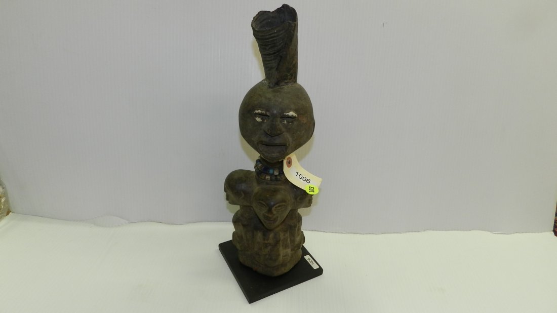 1006) African carved Figure with horn surrounded by 3: 1006) African carved Figure with horn surrounded by 3 or 4 half figures, on stand. From DR Congo. COND G, 16"