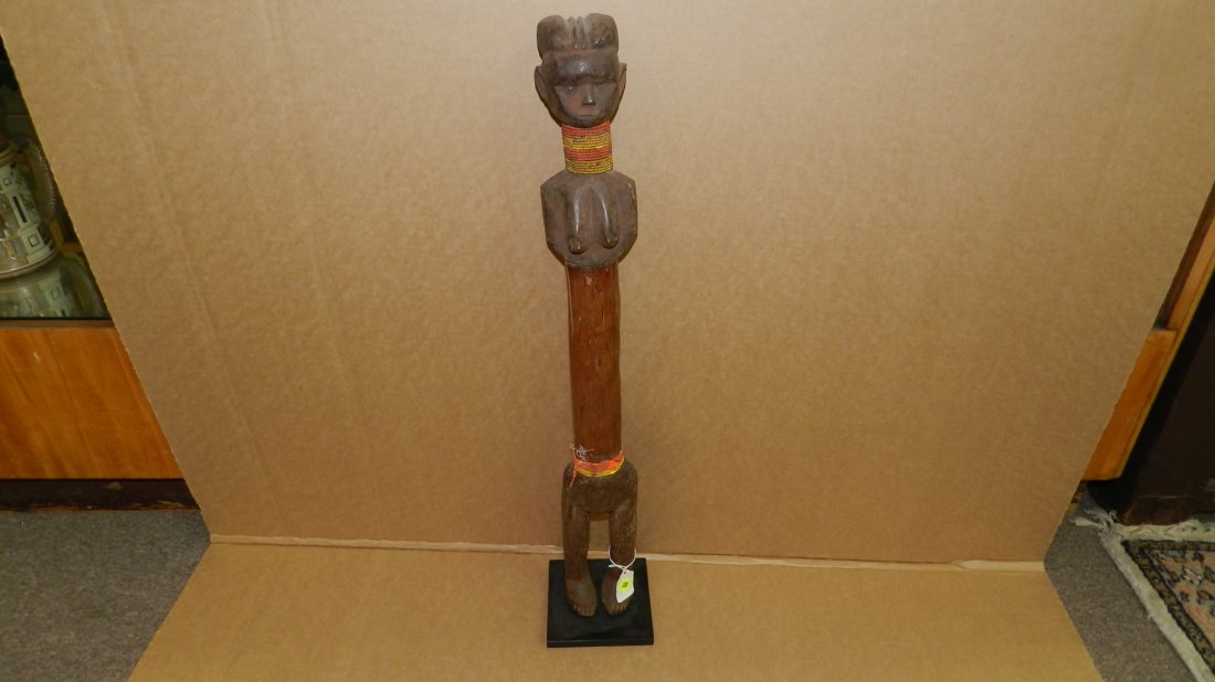 4130) East African standing female figure (Pestle: 4130) East African standing female figure (Pestle figure?), on stand, beaded, minor bead loss. From Tanzania. COND G, 27 1/4"