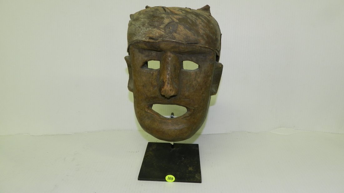 68) unique African hand carved Mask w/ simple features,: 68) unique African hand carved Mask w/ simple features, no scarifications, open mouth and eyes, forehead covered w/ skin, greyish brown patina on stand mask is 9 1/2 x 7 x 4 with stand 13" tall
