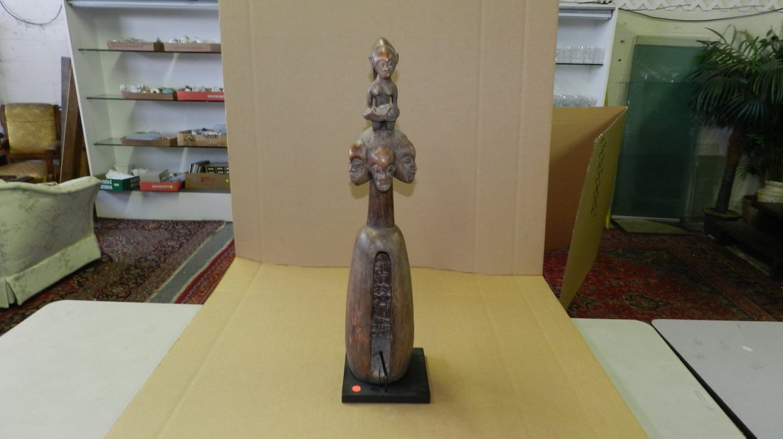308A) African carved Mbala Slit drum with 3 faces on to: 308A) African carved Mbala Slit drum with 3 faces on top; surmounted by maternity figure. From DR Congo. 31 1/2"