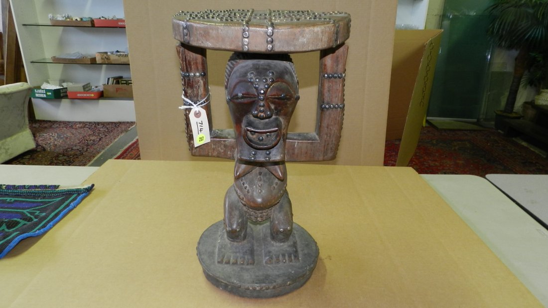 714) African Caryatid stool w/ tack pattern on seat; ta: 714) African Caryatid stool w/ tack pattern on seat; tacks throughout body & face. Songye tribe. From DR Congo. 20 3/4 x 12