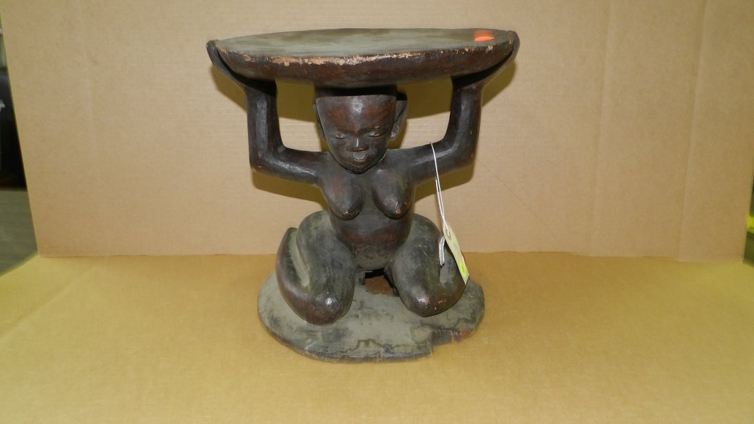 67) African carved Makonde caryatid stool. Kneeling: 67) African carved Makonde caryatid stool. Kneeling female figure supporting stool. From Tanzania. 13 1/2 x 12 1/2"