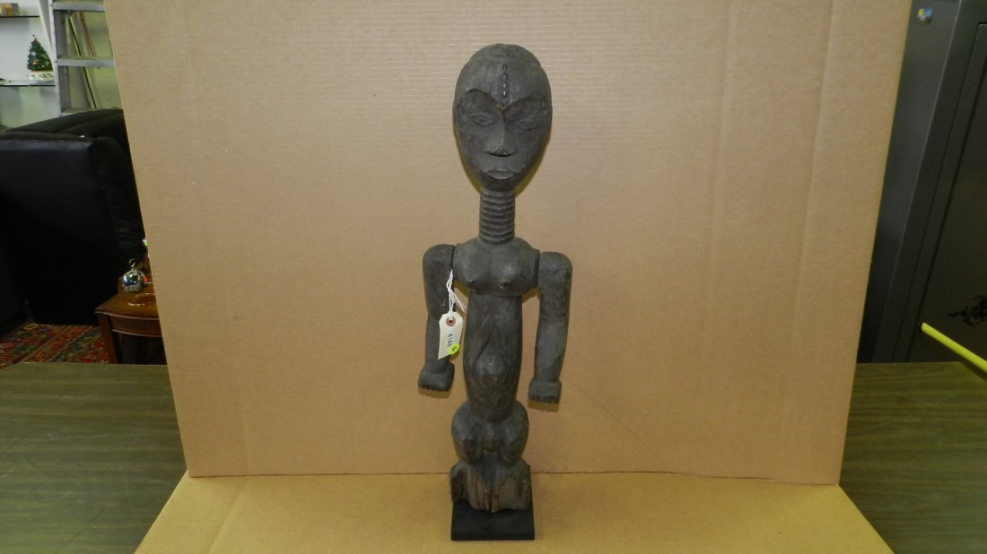 4148) African carved standing female figure on wood: 4148) African carved standing female figure on wood pedestal. From Tanzania. 28 1/2" w/stand