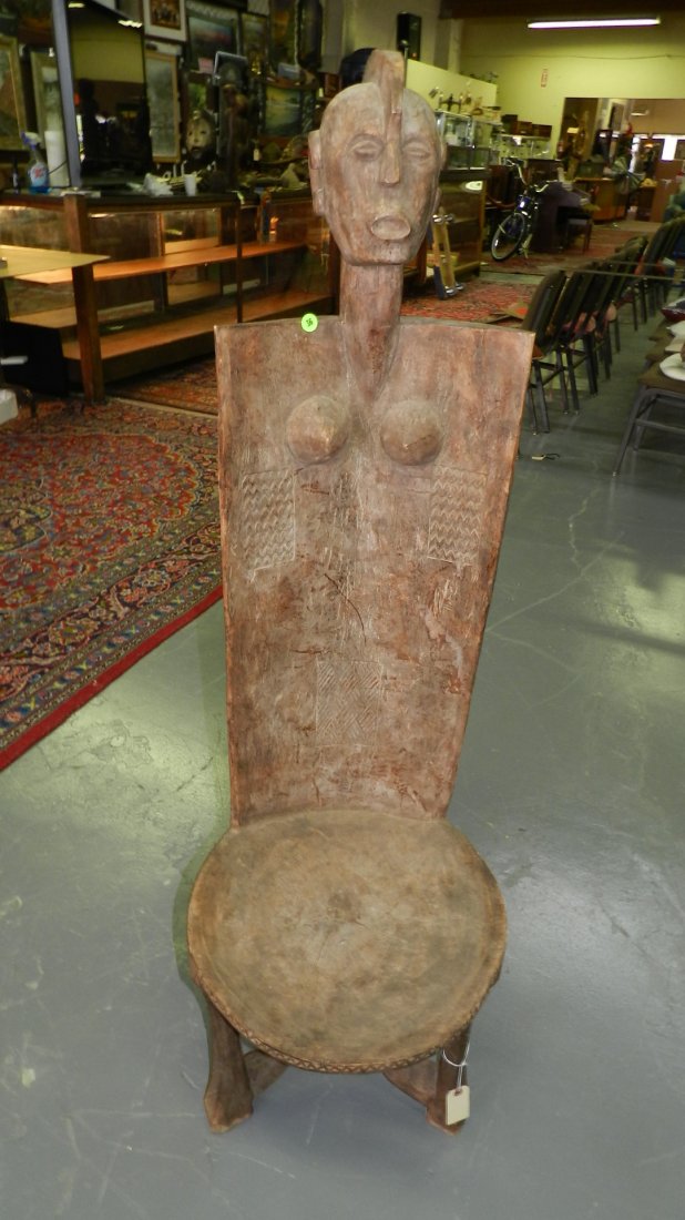 197) Large East African carved chair. Wood with: 197) Large East African carved chair. Wood with weathered brown surface. Rectangular back & abstract Shipping Alert * this item is larger than what our shippers can handle, we can still offer to ship 