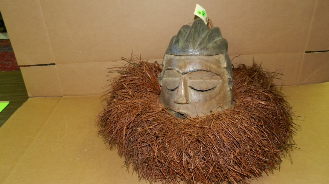 3083) African handmade & carved Suku helmet mask. DR: 3083) African handmade & carved Suku helmet mask. DR Congo, 18 x 18 with the raffia