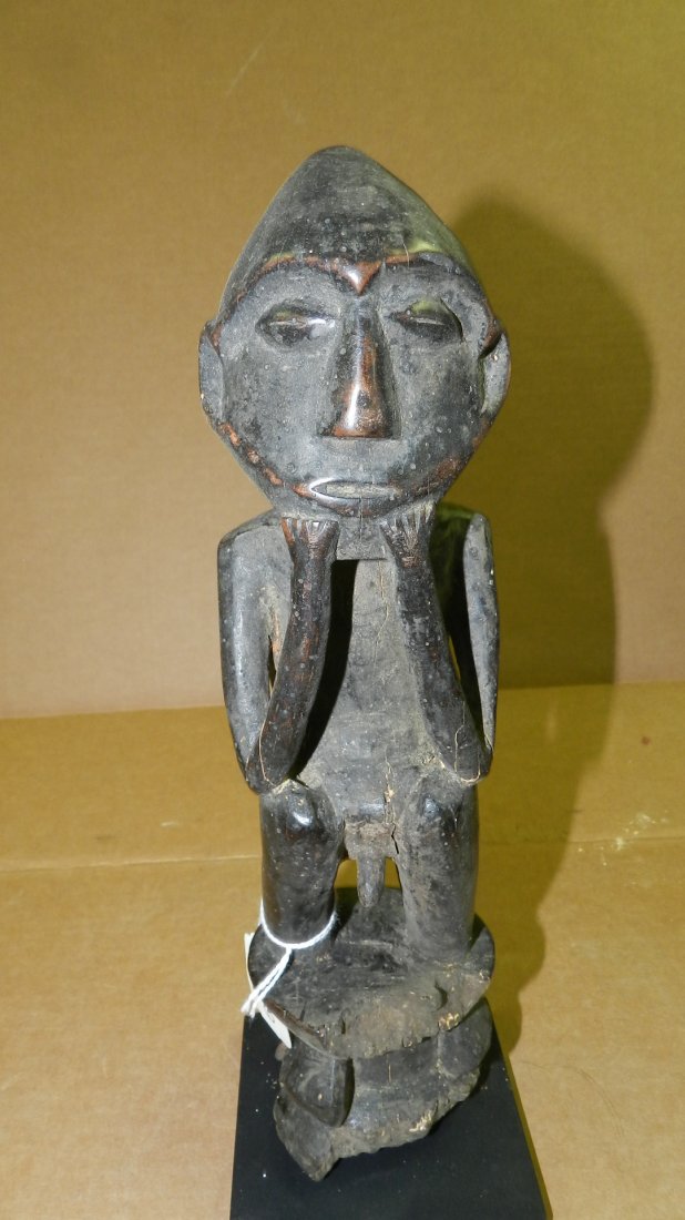 9139) carved African Squatting male figure on stool. (s: 9139) carved African Squatting male figure on stool. (stool well eroded. Cracked arms and behind left ear). On Stand. 13" DR Congo