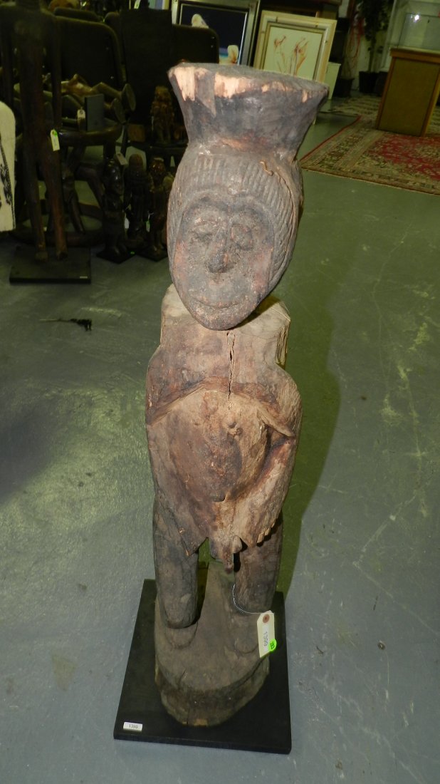 1399) African carved standing male figure on integral p: 1399) African carved standing male figure on integral pedestal and stand. 39" w/stand