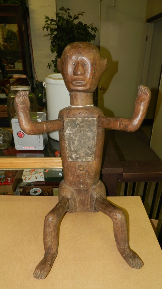 EAST AFRICAN FIGURE. Brown stained wood with metal shee: EAST AFRICAN FIGURE. Brown stained wood with metal sheet over chest, brass tacks on face and chest. Separately carved and attached arms, legs, and feet. In good condition, appropriate for age, origin,