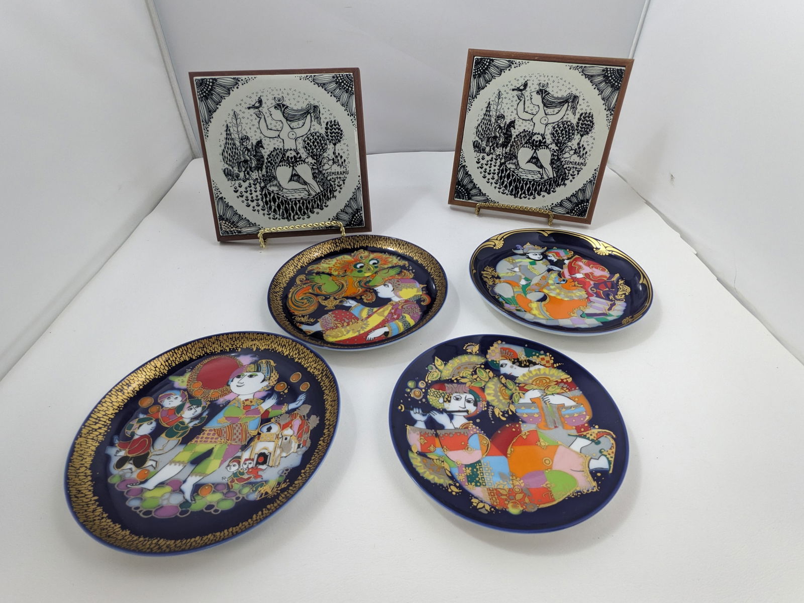 Bjorn Winblad plates and trivets: 4 Rosenthal 6" plates signed Bjorn Winblad, Orientalische Nachtmusik Ouverture Motiv I, Aladin und die Wunderlampe II, Zaubeynferd II, Aladin und die Wunderlampe V, and a pair of ceramic trivets in wo
