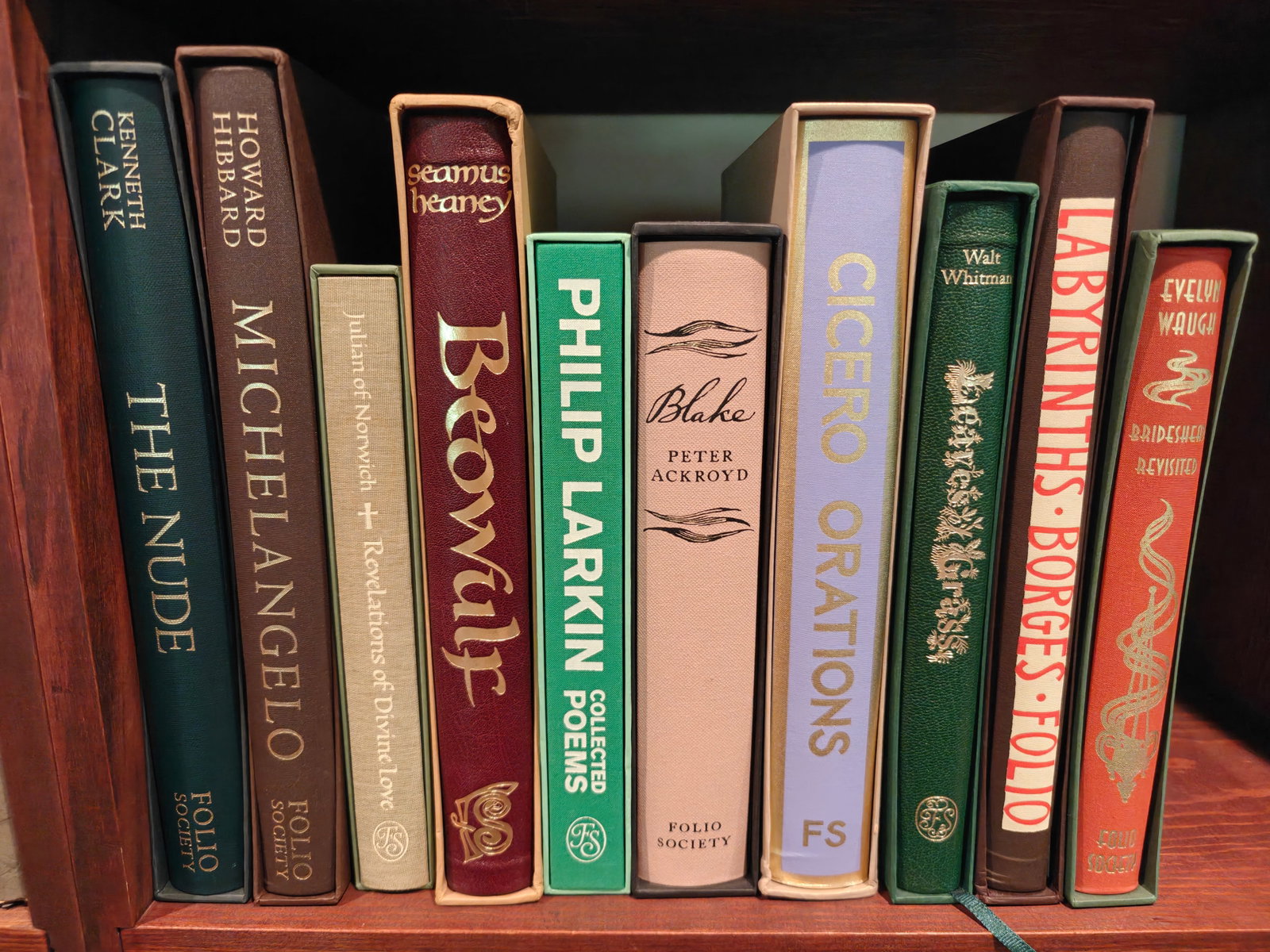 Folio Society Books Shelf Five, 10 books: The Nude, Michelangelo, Julian of Norwich, Beowulf, Philip Larkin Collected Poems, Blake, Cicero Orations, Leaves of Grass, and Labyrinth, Brideshead Revisted