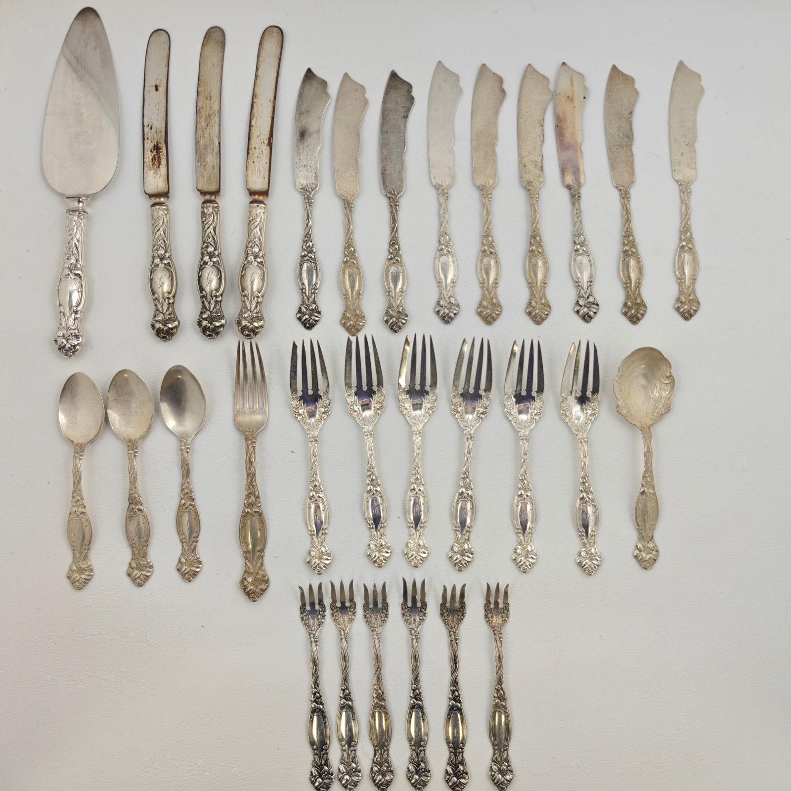 Sterling Dinnerware Set, 30 pieces, 936g: Elegant sterling silver dinner service featuring ornate handles in a flowing floral motif. The set includes 1 dinner fork, 6 salad forks, 3 teaspoons, 6 shrimp forks, 9 butter knives, 3 dinner knives,