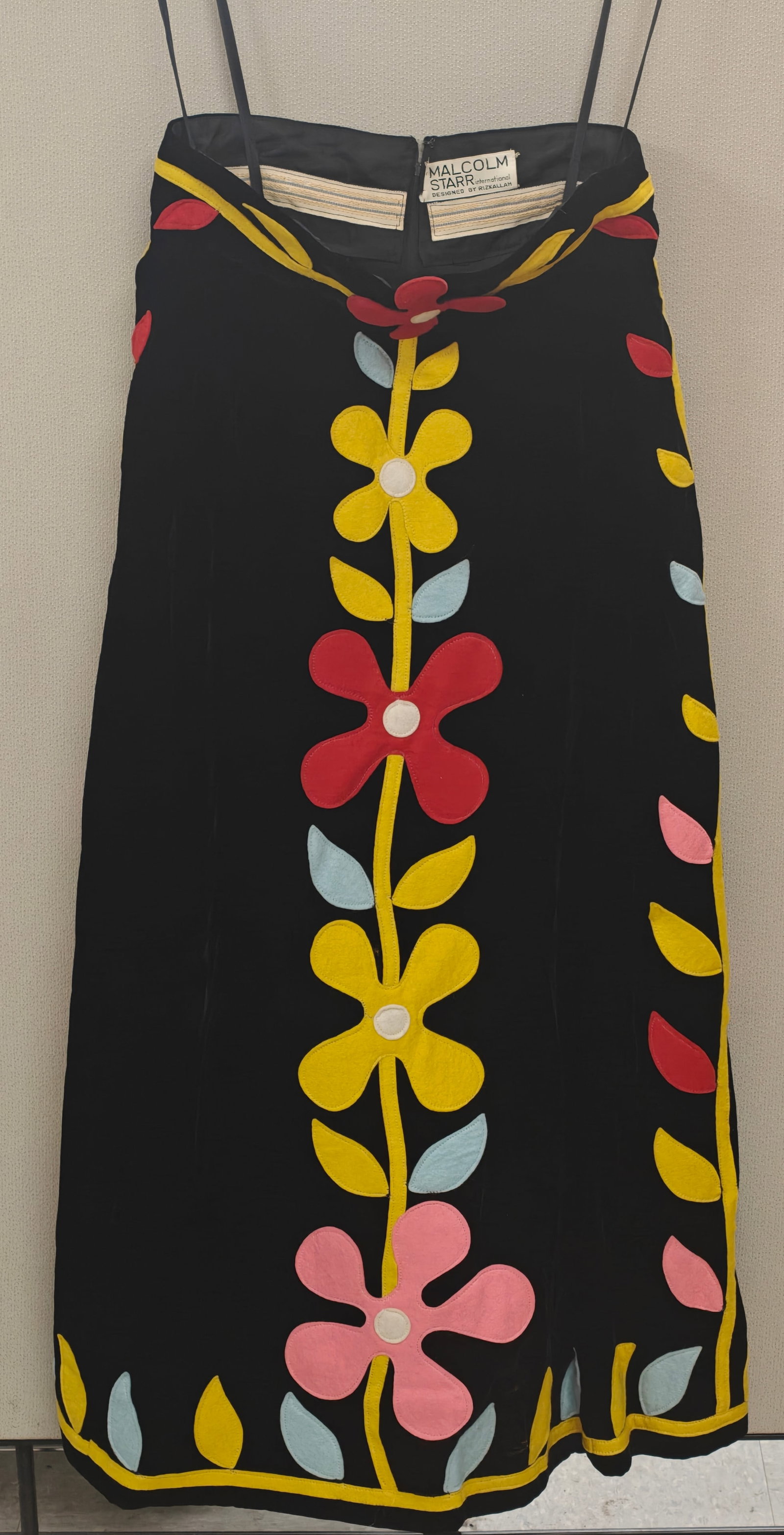 Rizkallah for Malcolm Starr Black Velvet Hostess Skirt with Felt Floral Appliques: Rizkallah for Malcolm Starr velvet hostess skirt featuring vibrant felt flower appliques in red, yellow, pink, and blue on a black background. High-waisted with a back zipper and grosgrain waistband d