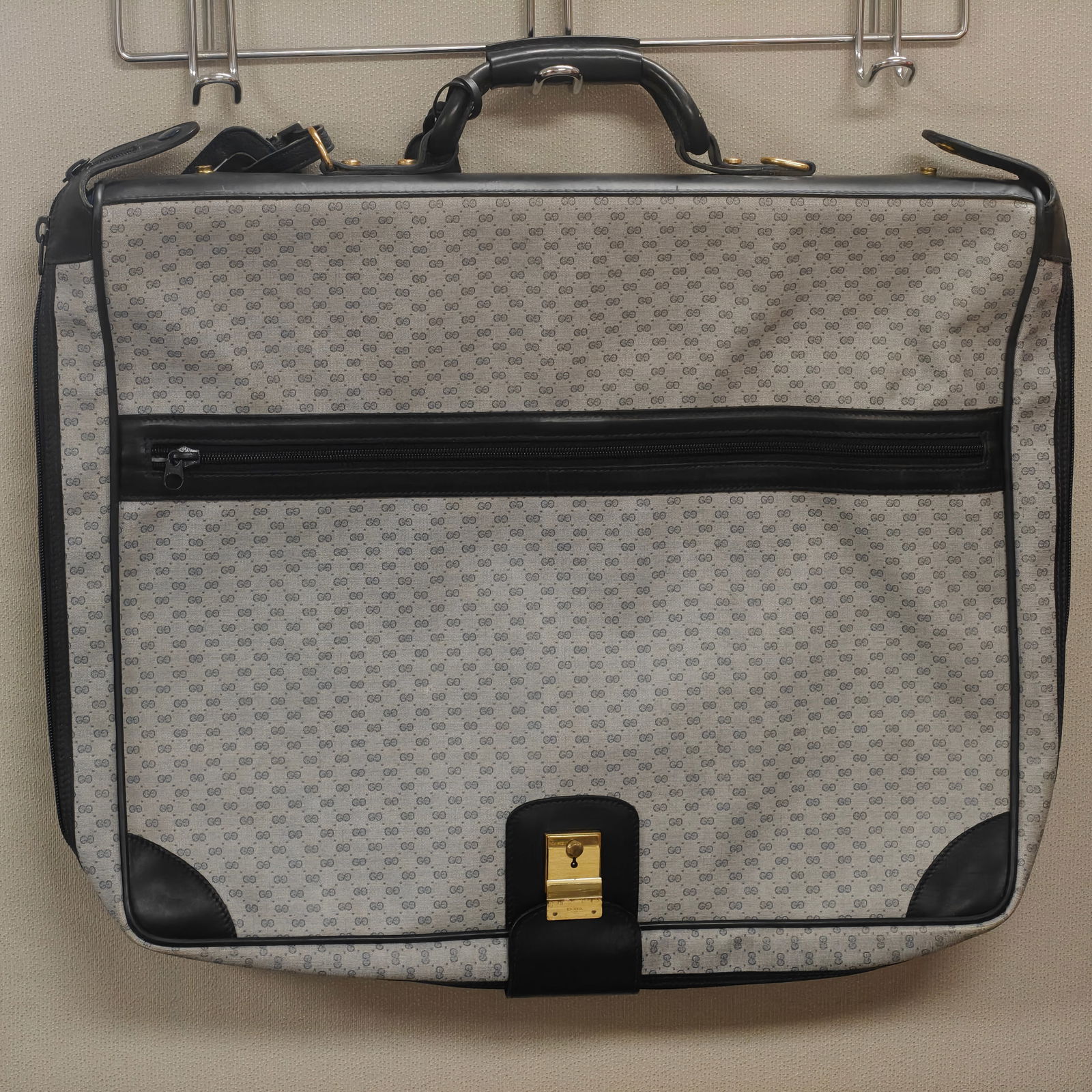 Vintage Gucci Monogram Canvas Garment Bag - Blue, 24x38: Classic vintage Gucci garment bag crafted in blue/grey GG monogram canvas with black leather trim and gold-tone hardware. Features a front zippered pocket, reinforced corners, and a secure clasp closu