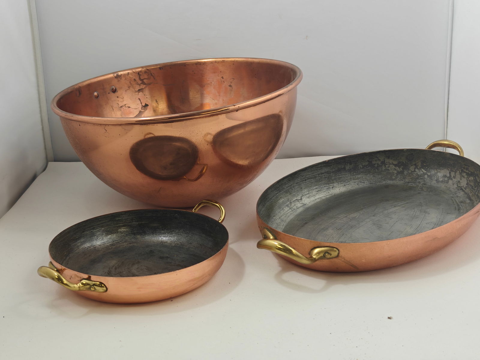 Copper cookware: Copper mixing bowl 12.5 inches round 6 inches tall, one oval dish 16.25 x 9.5 x2 marked bongusto, and another 9x7.25x1.5 inches marked Made in Italy