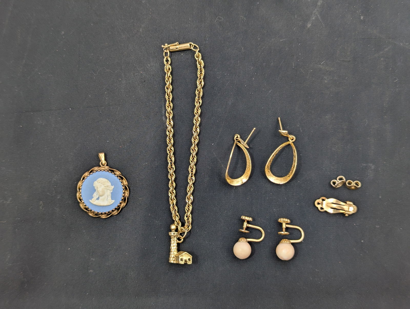 14K Gold Jewelry: One Bracelet, with lighthouse charm, Two pairs earrings, one with pink coral/pearl/ornament, Wedgwood cameo pendant, three earring backs (one part of broken clip on earring), all marked 14K. Weight of
