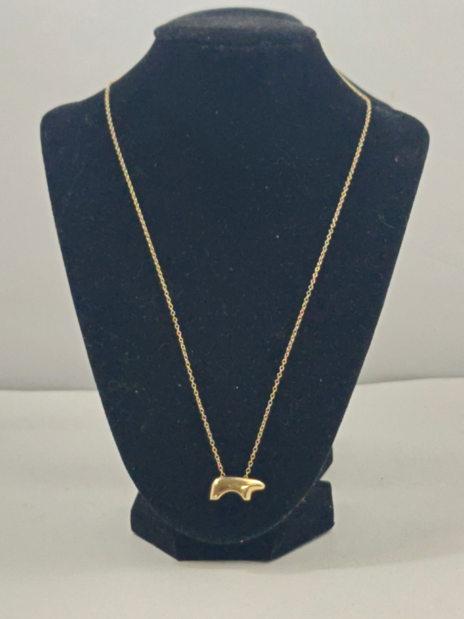 14K Gold Bear Pendant Necklace: 14 karat yellow gold necklace with stylized bear-form pendant, polished finish, suspended from a fine gold chain; stamped 14K; total weight approximately 7 grams; chain length approximately 28 inches.