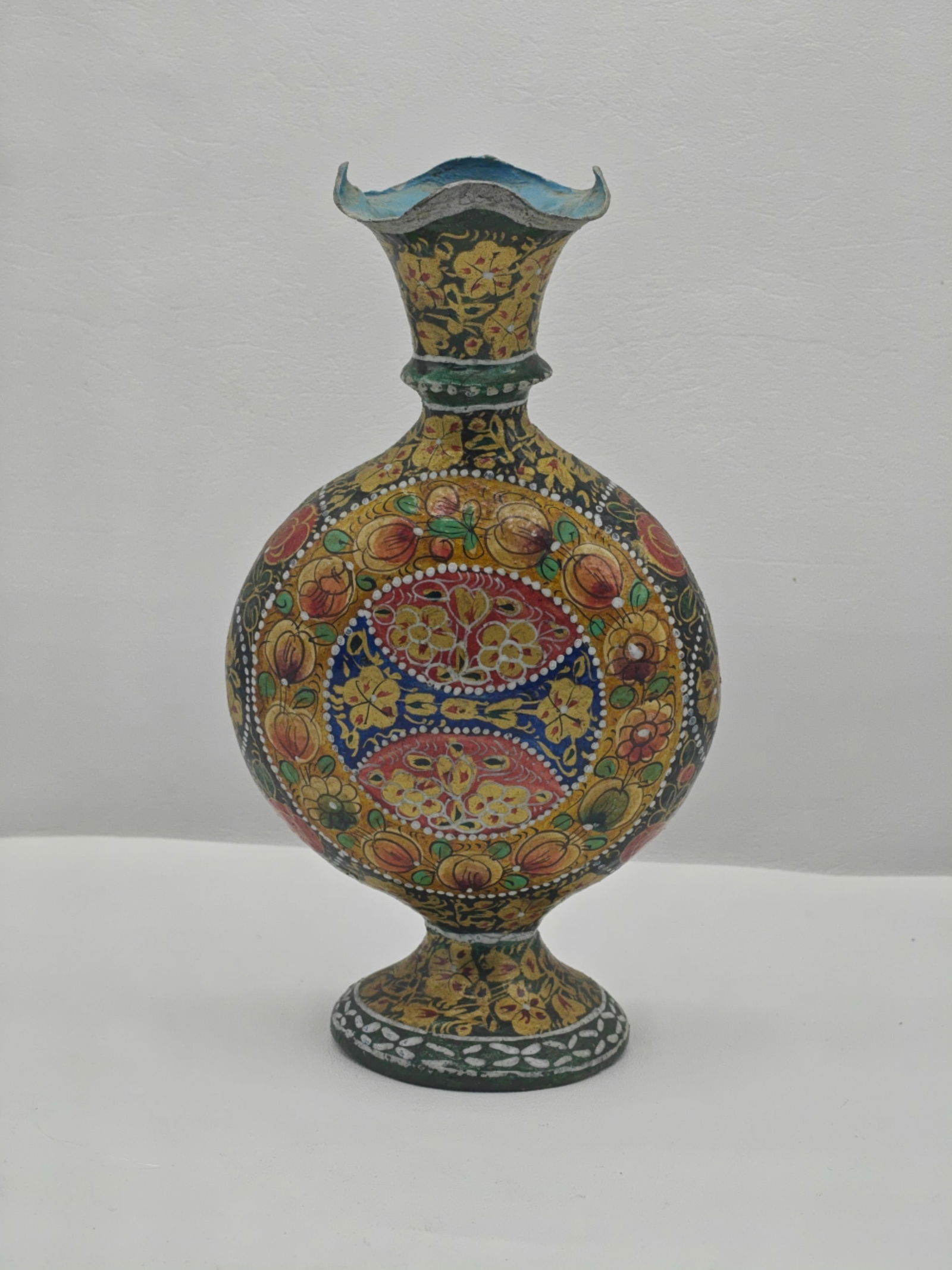 Hand Painted Camel Skin Decorative Vase 9.5 Inches: Handcrafted camel skin vase with a bulbous body and flared rim, decorated with intricate hand-painted floral and geometric motifs in vibrant reds, yellows, greens, and blues. The design features symme