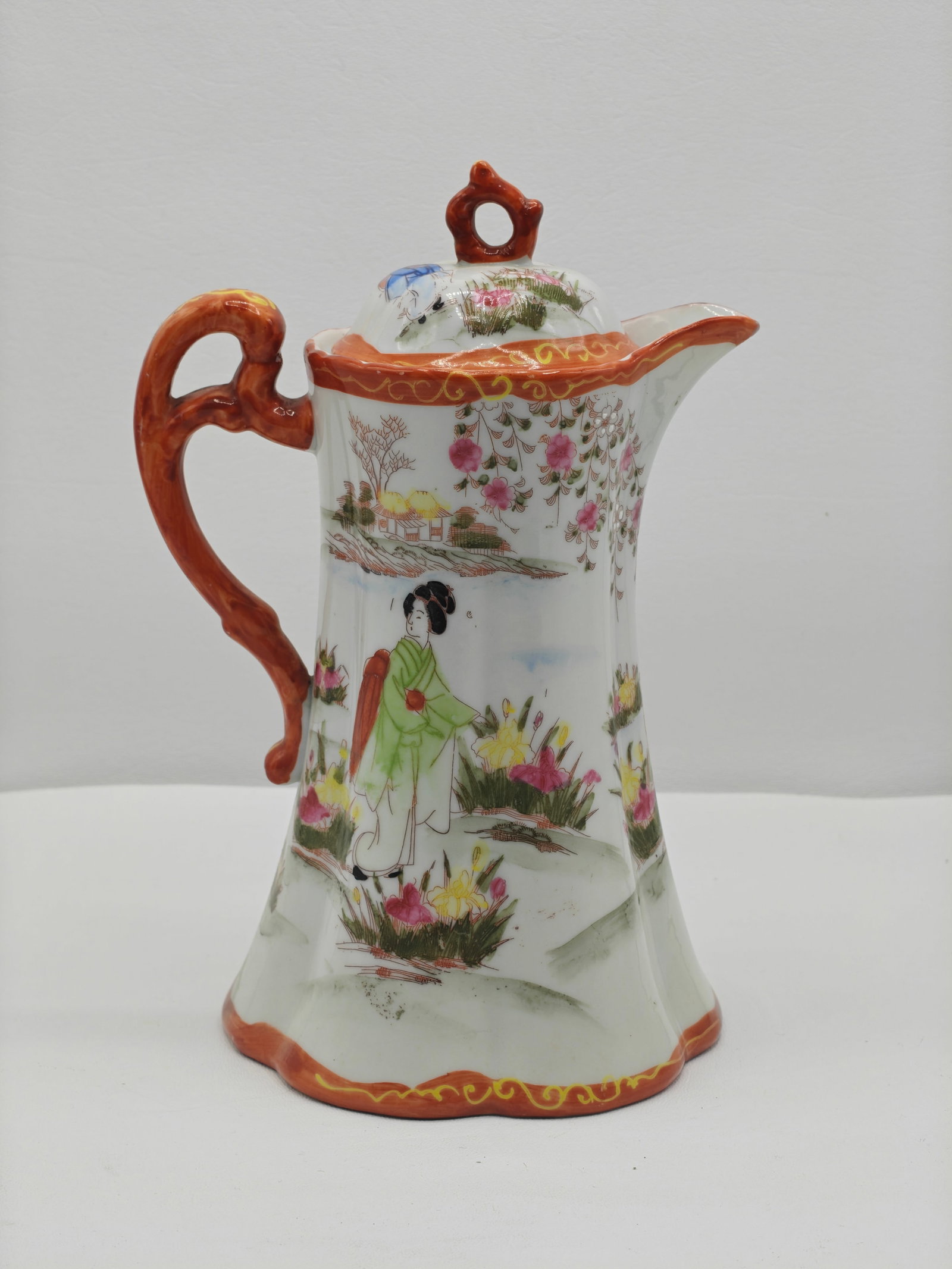 Japanese Kutani Style Porcelain Chocolate Pot with Cover, Figural Scene, 10 Inches: Japanese porcelain chocolate pot in Kutani style, decorated with hand-painted figural scenes of women and attendants in a garden landscape with floral and scenic elements in soft enamel colors. The po
