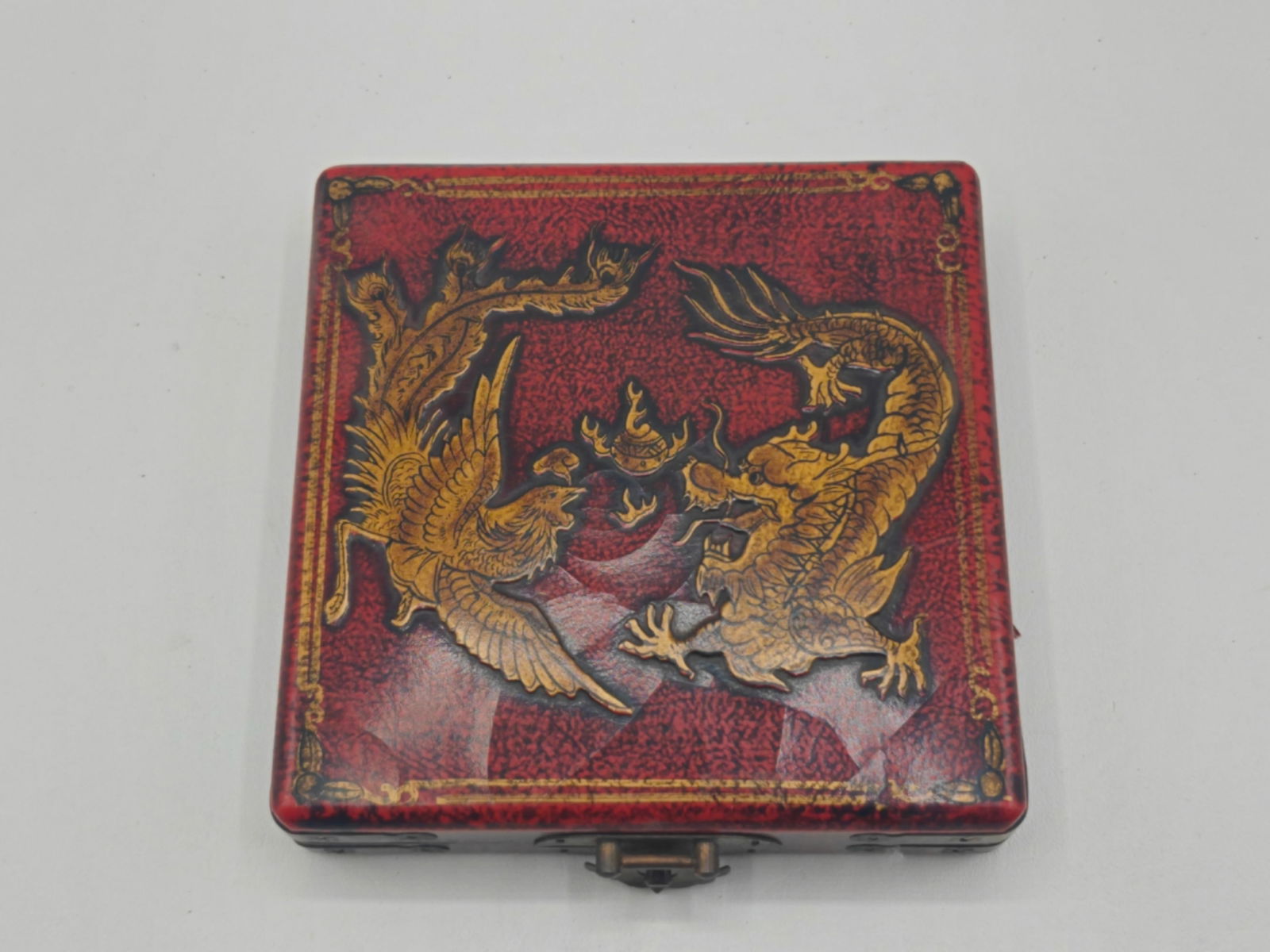 Vintage Chinese Feng Shui Luo Pan Compass in Lacquered Case: Vintage Chinese Feng Shui Luo Pan compass housed in a decorative red lacquered case featuring gilt dragon and phoenix motif. Interior reveals traditional multi-ring compass dial with Chinese character