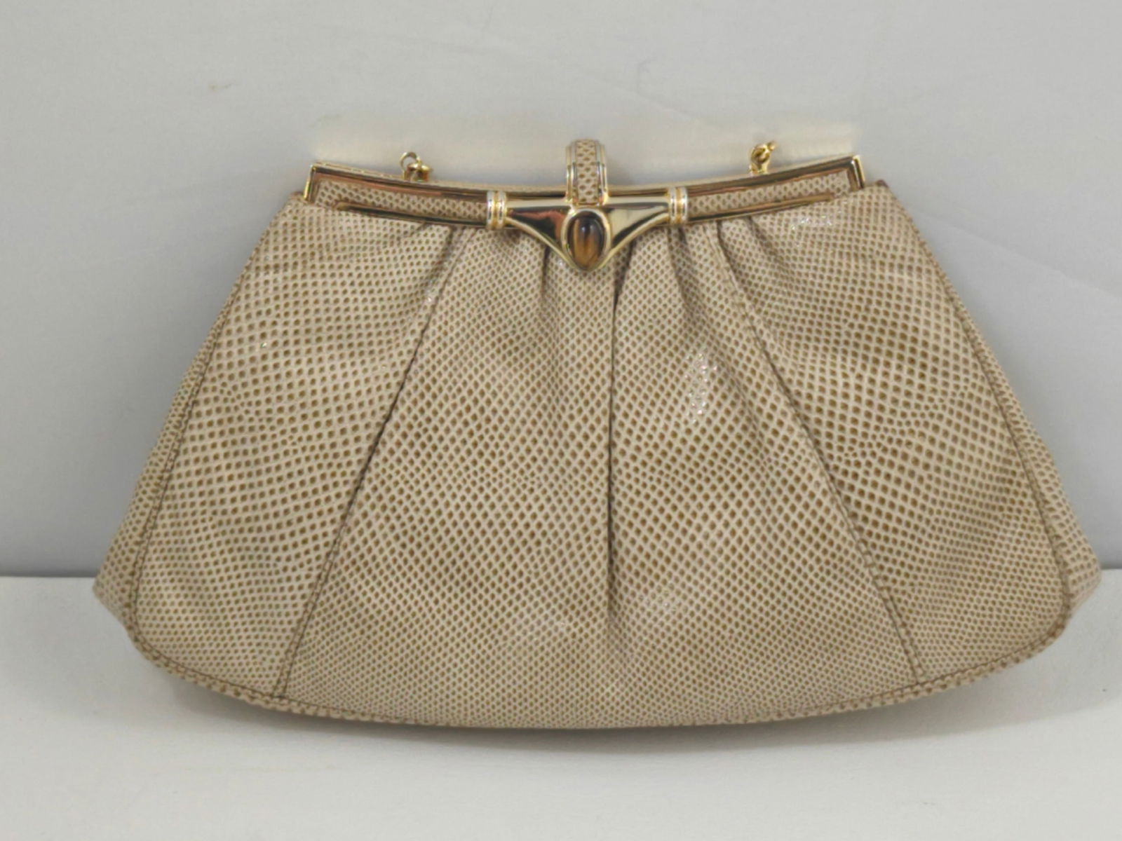 Vintage Judith Leiber Taupe Snakeskin Evening Clutch with Tiger’s Eye Clasp, Chain Strap, Dust Bag: Vintage Judith Leiber evening clutch in taupe snakeskin featuring a softly gathered body and structured gold-tone frame. The clasp is set with a polished tiger’s eye stone, adding a refined focal de