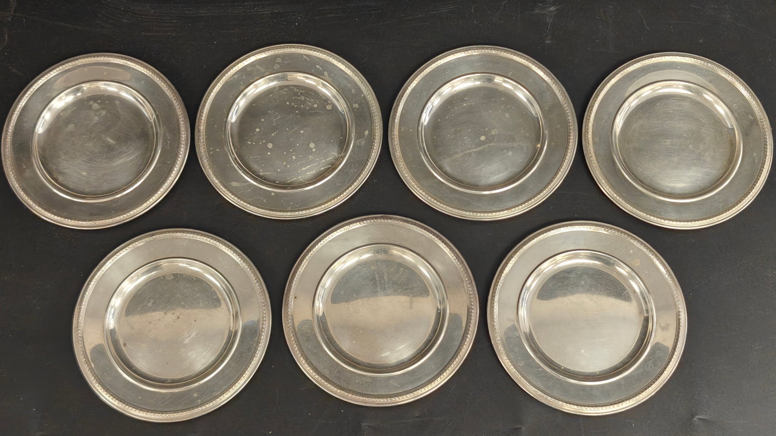 Seven Gorham Sterling Silver Bread & Butter Plates: A matched set of seven Gorham sterling silver bread and butter plates, each featuring a classic beaded border and elegant, understated design suitable for both traditional and contemporary table setti