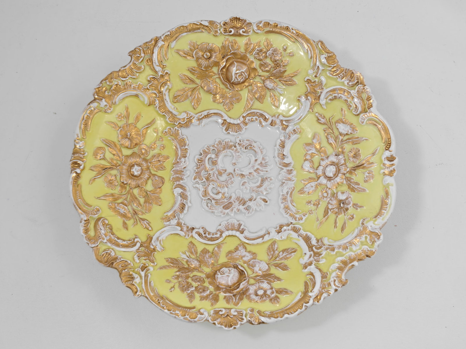 Antique Meissen Yellow Ground Floral Porcelain Charger: Antique Meissen porcelain charger featuring an ornate Rococo molded rim with raised floral decoration, yellow ground panels, extensive gilt highlights, and a central white reserve with gilt scrollwork