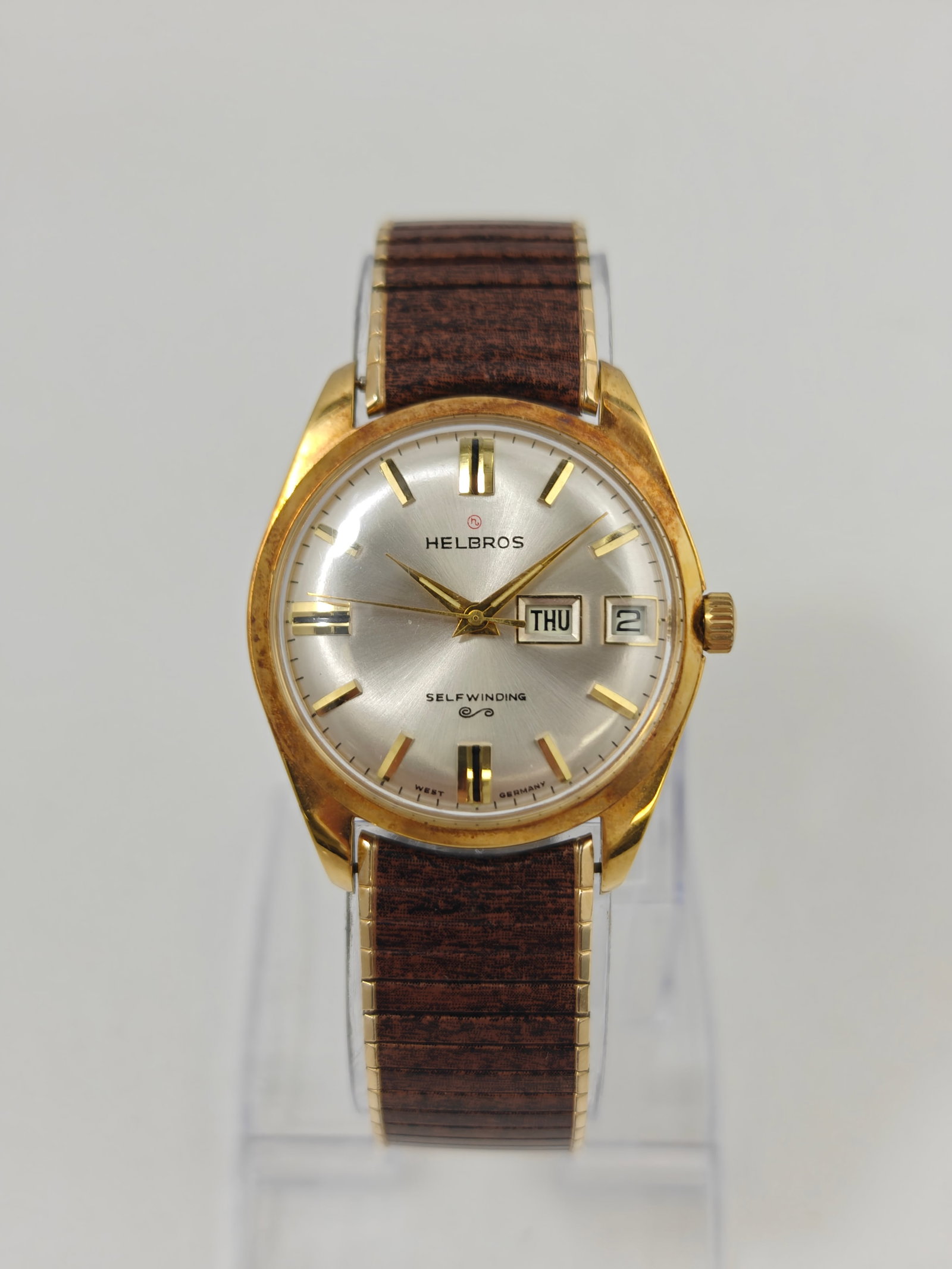 Helbros Automatic Day-Date Gold Plated Wristwatch: Vintage Helbros self-winding wristwatch featuring a silver-tone dial with applied gold-tone hour markers, center sweep seconds, and day-date display at 3 o'clock. Marked "West Germany" on the dial and