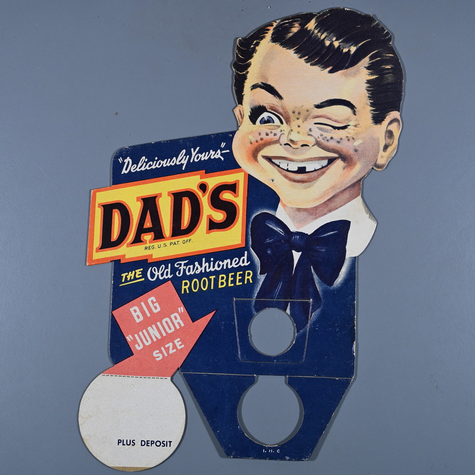 Dad's Old Fashioned Root Beer Bottle Topper: Paper over cardboard. Marked I.H.C. below the lower tab that fits over the bottle. Undated. It is about 11 1/2 inches tall x 7 1/2 inches wide.