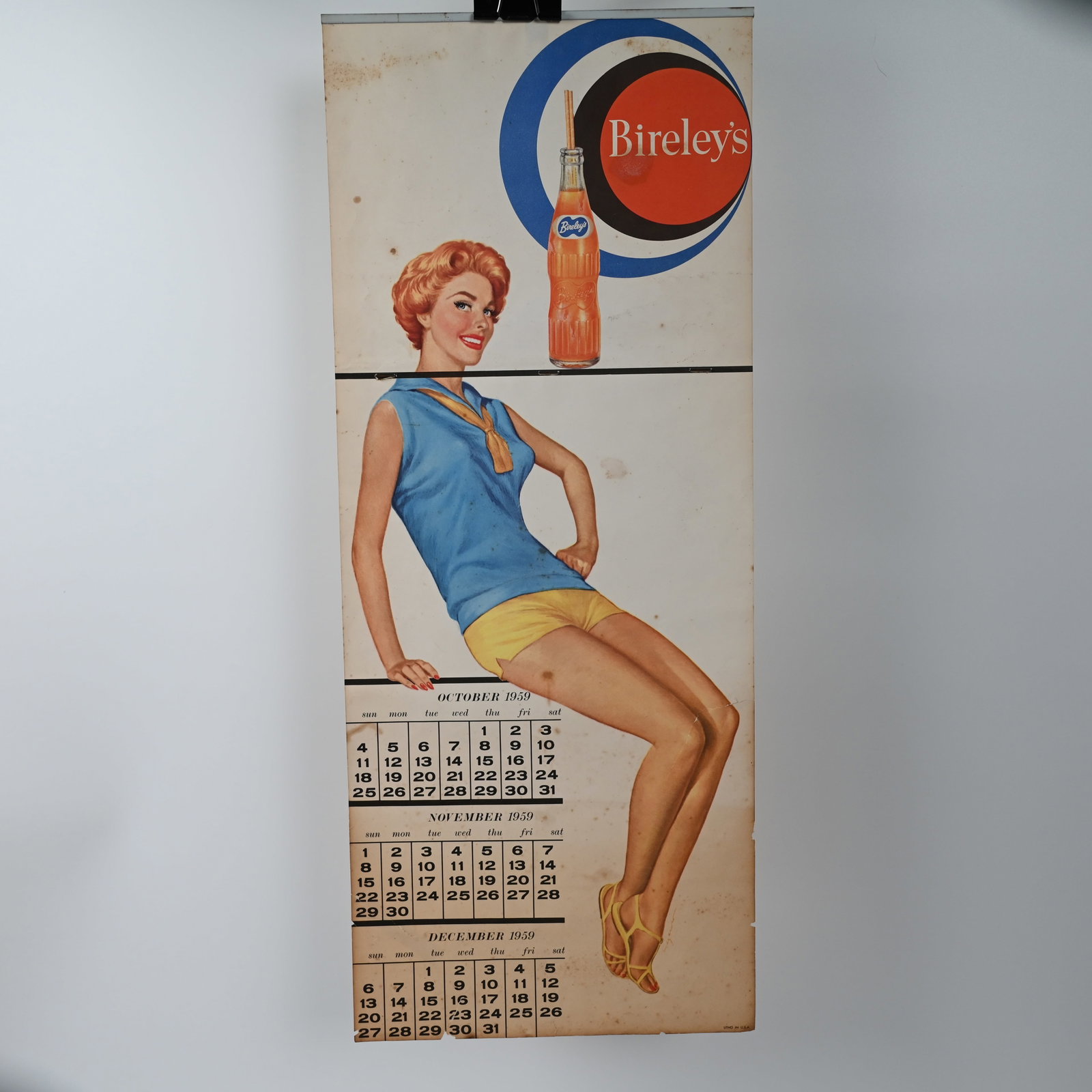 Bireley's 1959 Pin-up Calendar Advertisement: Bireley's 1959 calendar with the months of October - December, 1959. We suspect that the calendar was issued with seasonal clothing for each quarter of the year. That would account for the black line