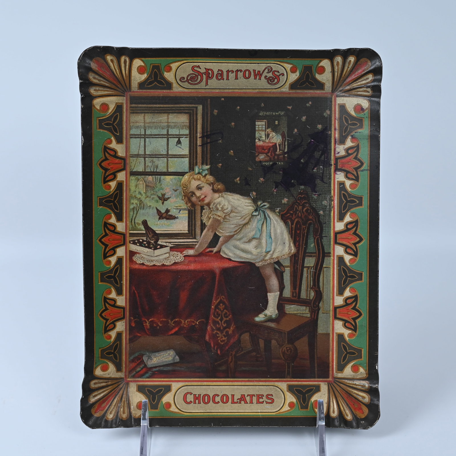Sparrow Chocolates Serving or Tip Tray: Sparrow Chocolates were sold 1892 - 1928. Because of the tray / product image hanging on the wall, it is in our opinion, from the late 1880s - early 1890s. Using product images within a picture was a 