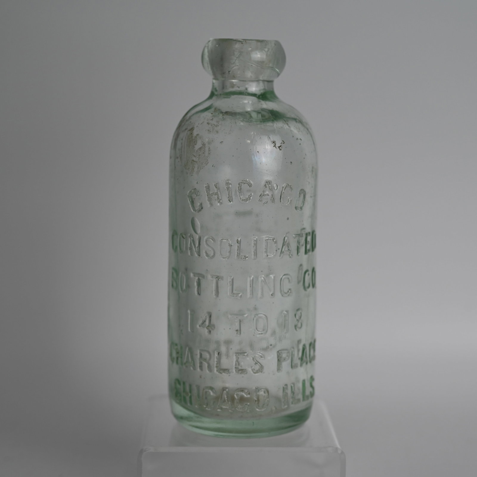 Chicago Consolidated Bottling Co Blob Top Beer Bottle: Likely a beer bottle. 14 to 18 Charles Place Chicago ILLS. Back: Trade Mark Registered and an image. Approximate size: 6 1/2th inches tall, 2 3/8 inches diameter.
