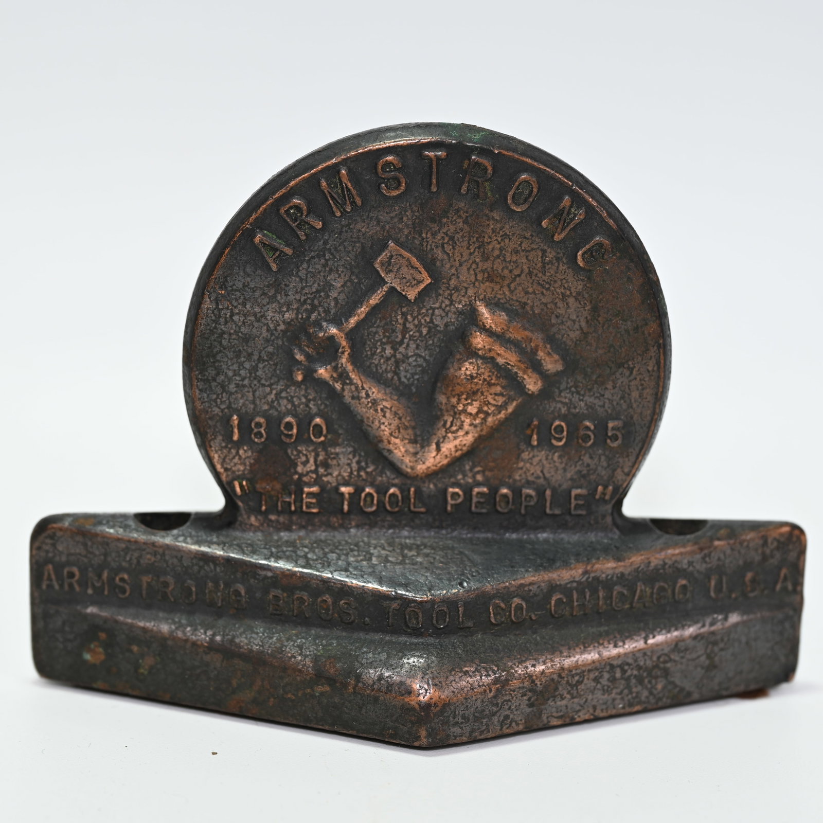 Armstrong The Tool People 75th Anniversary Advertising Paperweight: 1890 - 1965 75 Years of Making Fine Tools. And, as marked, made of Drop Forged Steel. Also designed to hold pens or pencils. Appears copper flashed or plated. About 3 1/4 H x 4 1/2 W x 2 D inches