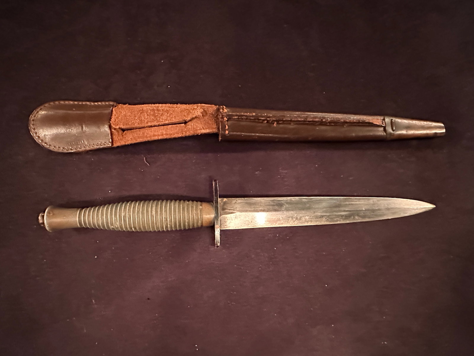 WWII Fairbairn Sykes Fighting Knife with Sheath: This is a thick bladed hand ground Fairbairn Sykes commando fighting knife. We could not find any markings on the knife or sheath. Fraying of sheath material as shown in the picture. Please review the