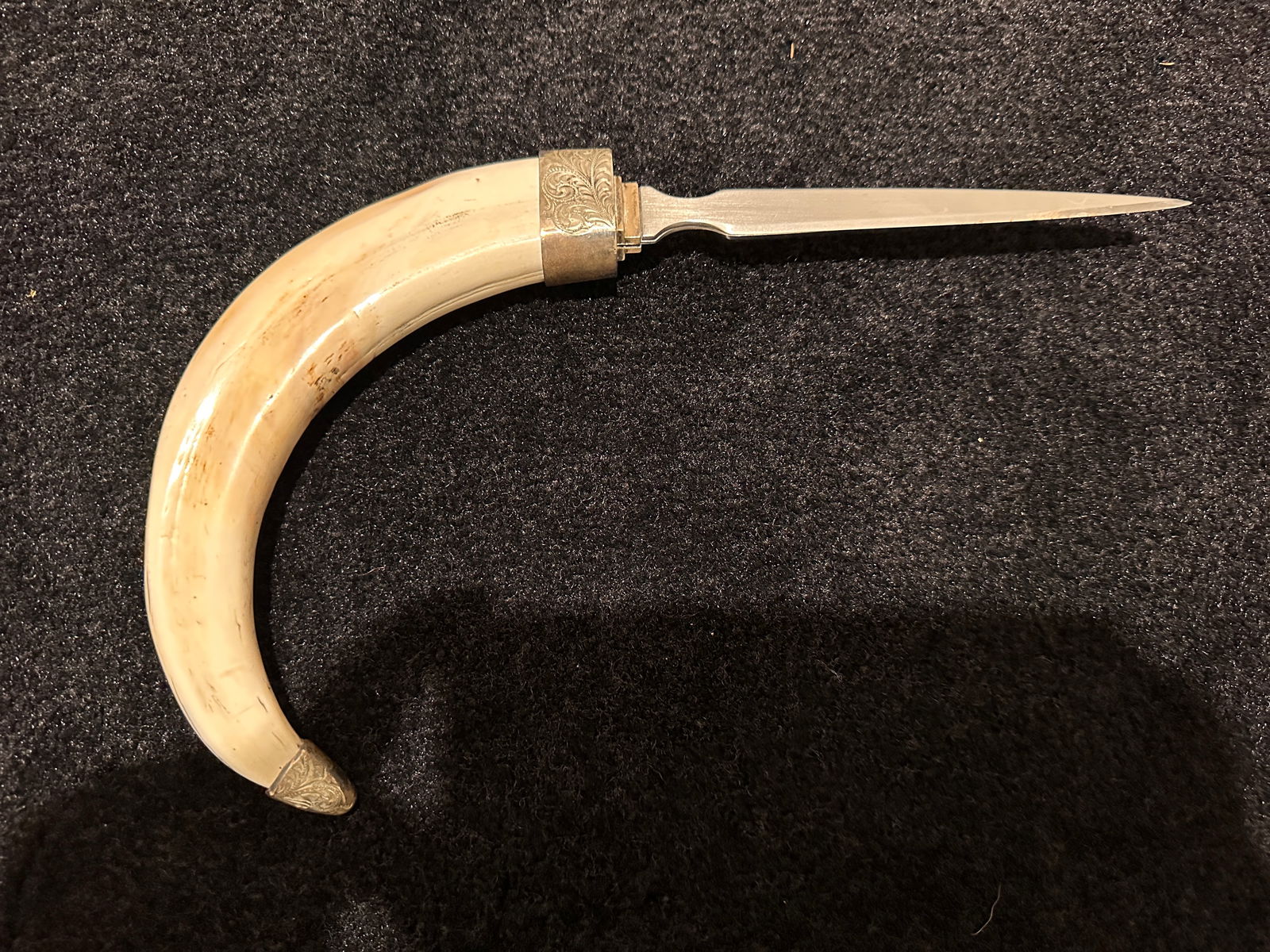 Warthog tusk letter opener: Warthog tusk letter opener with silver accents. The blade measures approximately 6 inches in length. The tusk measures approximately 10 inches in length. The total length is approximately 16 inches. T