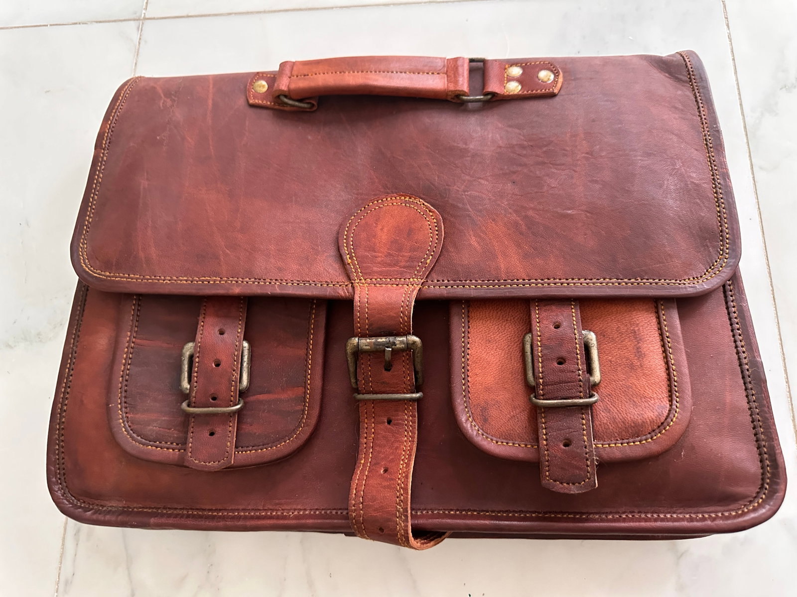 Leather messenger bag with strap: Leather messenger bag with strap and green lining. This is very heavy, thick, and manufactured with outstanding quality. We could not find a tag. The size is approximately 15 inches long by 12 inches 