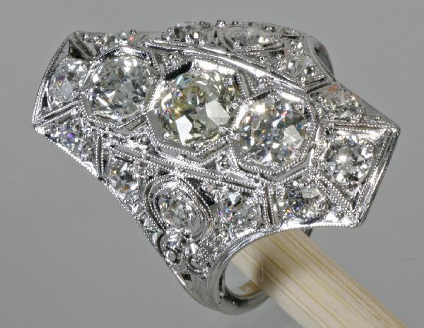 Edwardian Platinum & Diamond Ring Circa Early 1900: Ladies Edwardian platinum & diamond ring circa early 1900. Filigree design. Total (7) old mine cut diamonds in center and sides weighing approximately 2.25 ct. There are (12) small mine cut diamonds t