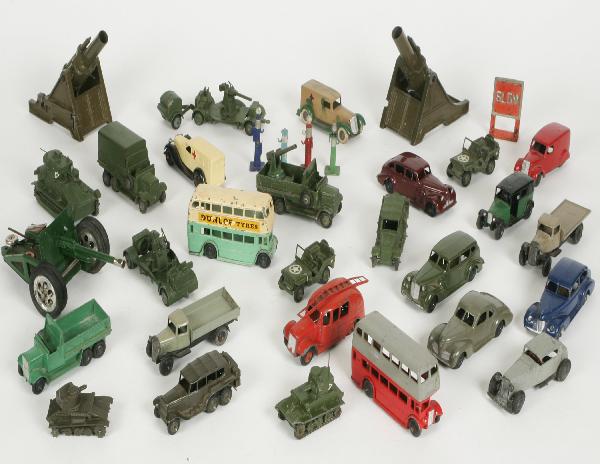 Cast Metal Cars Trucks Etc: Assortment of toy Tanks, Cars, Buses, Cannons and other cast metal toys including dinky, etc. Approximately 30 plus objects. As-Is