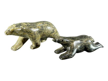 JUTAI NOAH, NORTH AMERICA, A VINTAGER INUIT CARVED SOAPSTONE FIGURE OF A RECUMBENT POLAR BEAR: JUTAI NOAH, NORTH AMERICA, A VINTAGER INUIT CARVED SOAPSTONE FIGURE OF A RECUMBENT POLAR BEAR Together with a larger carved soapstone polar bear, signed &#8216;John .N.&#8217; to underside. (largest h