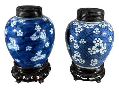 TWO CHINESE BLUE AND WHITE PORCELAIN GINGER JARS Both decorated with geometric blossom flowers,: TWO CHINESE BLUE AND WHITE PORCELAIN GINGER JARS Both decorated with geometric blossom flowers, having wooden covers and stands, one having double blue circle to underside. (largest (without stand) h