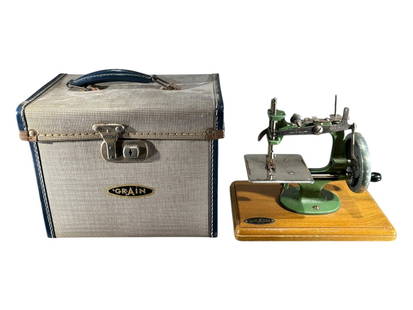 A VINTAGE GRAIN PORTRABLE SEWING MACHINE IN GREEN Housed in original carrying case. (sewing: A VINTAGE GRAIN PORTRABLE SEWING MACHINE IN GREEN Housed in original carrying case. (sewing machine h 20cm x w 22.5cm x d 15cm)