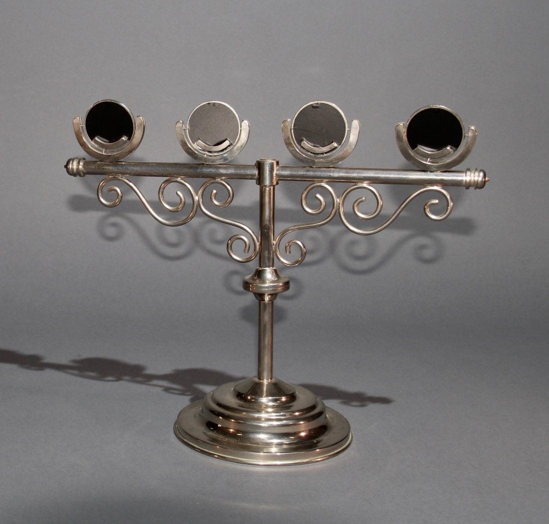 COIN STAND: Ornate metal stand that is gimmicked for the production of four coins (up to silver dollar size) without the use of sleight of hand. Beautifully crafted. Condition: Excellent.