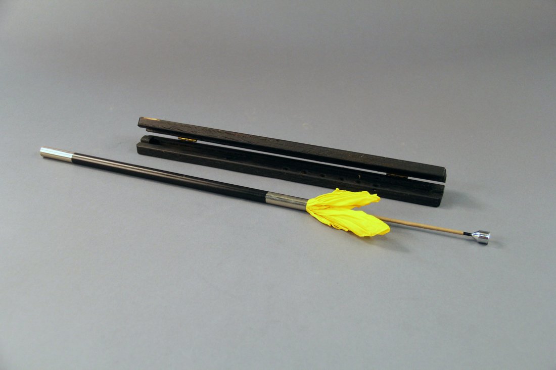 Silk Vanishing Wand: American. Circa 1930. A piece of paper is formed into a cone and a colored silk dropped inside. After stirring the cone with his wand, the magician unrolls the paper to reveal the silk has vanished. C