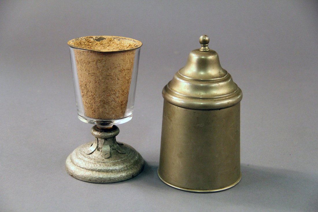 Thayer Bran Glass: Circa 1930. Glass atop a silver gesso wooden pedestal is filled with bran. A nickeled cover is placed over the glass and when removed, the bran has transformed into candy or other small items. Conditi