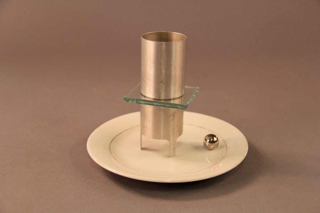 Thayer U-235: Circa 1940. A steel ball (allegedly made of uranium U-235 isotope) penetrates a small piece of glass that is sandwiched between two metal tubes, dropping on to a plate, below. Novel patter and present