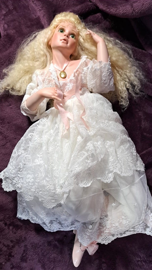 Blanford Porcelain Doll in White Lace Dress with Pink Ballet Shoes and Gold Locket: 36x10x10 5lbs High Estimate: 35 Low Estimate: 15